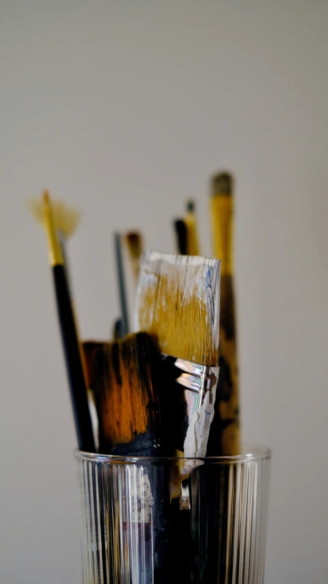 the brushes are in the glass, and the other one is yellow