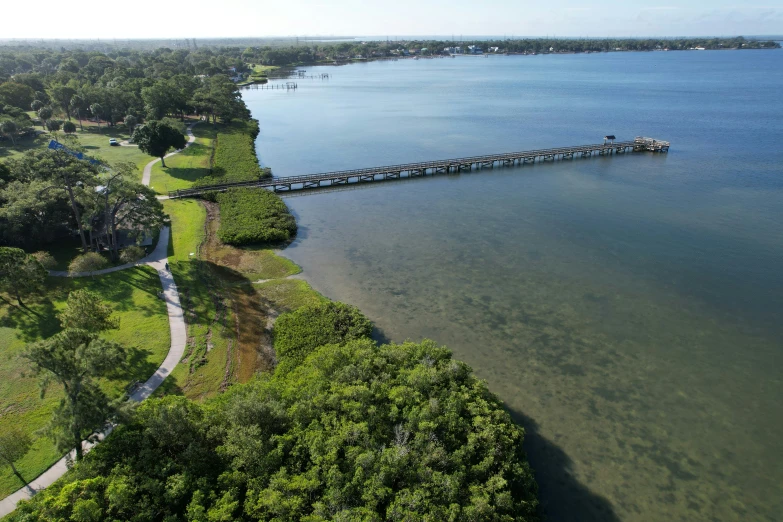 a bird's eye view of a long, wooded walkway leading to the water