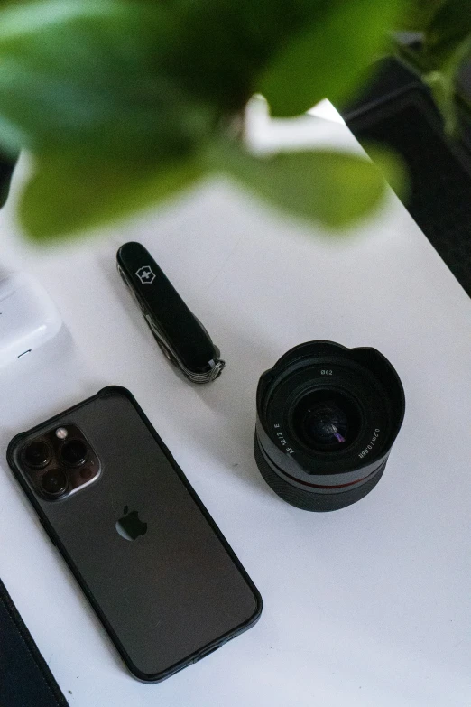 some electronics on a table, such as phone and camera