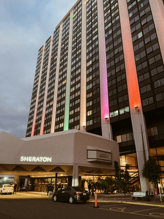 a modern looking el at night with car in foreground