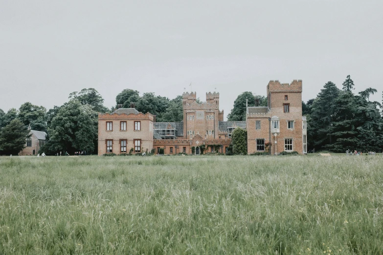 an old fashioned building sits on a grassy field