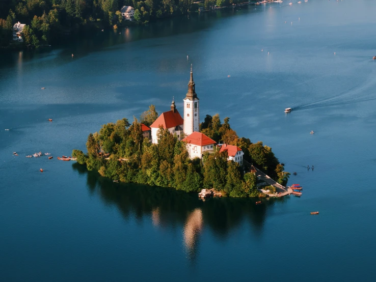 a small island with a building and red roof on the water