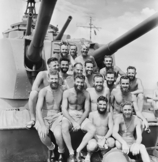 a group of men pose for a po by a large tank