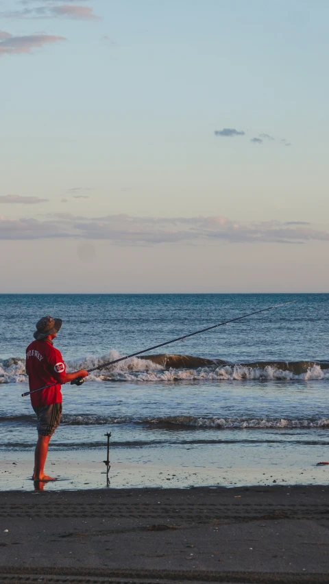 a person standing on the beach flying a kite