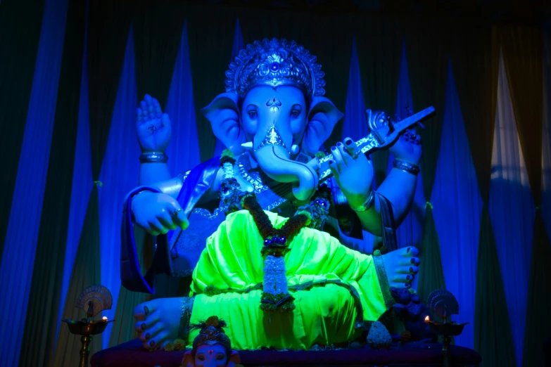 a large statue of a hindu god with a gun in his hand