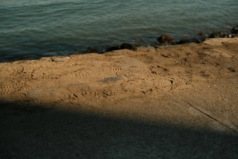 sand at the beach has rocks and water and sand