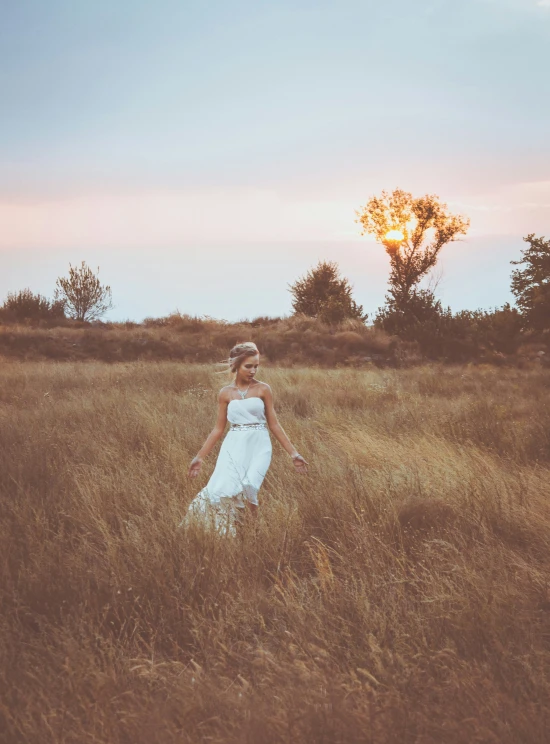 a young woman standing in a field with her hair down