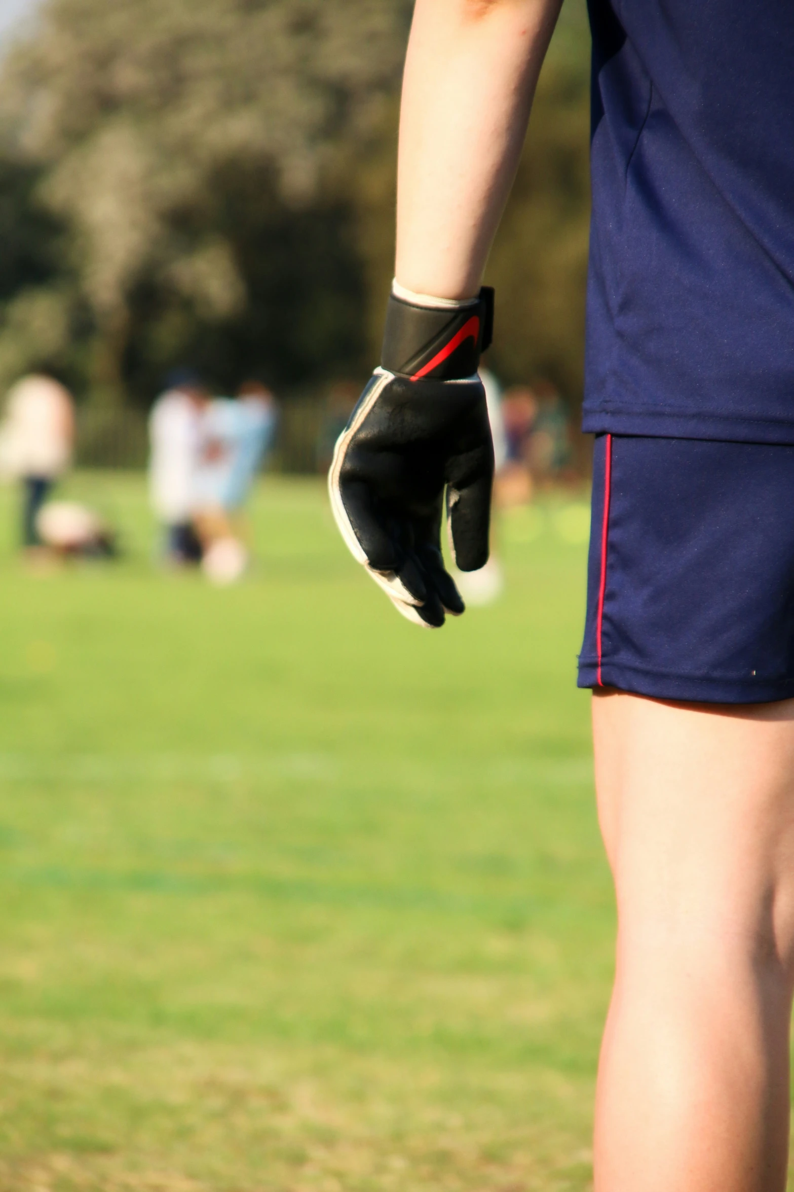 someone in a blue soccer uniform wearing batting gloves