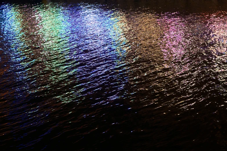 an aerial view of water and the lights reflected on it