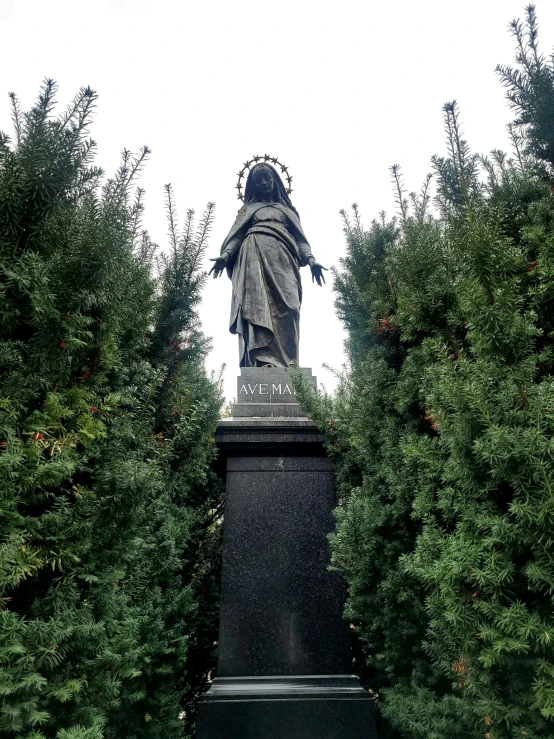 the statue stands in front of some trees