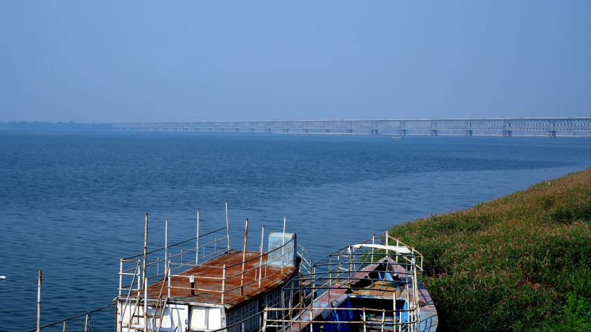 some old boats in the water next to a bridge