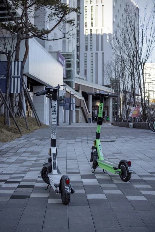 two motorized scooters that are sitting in the street