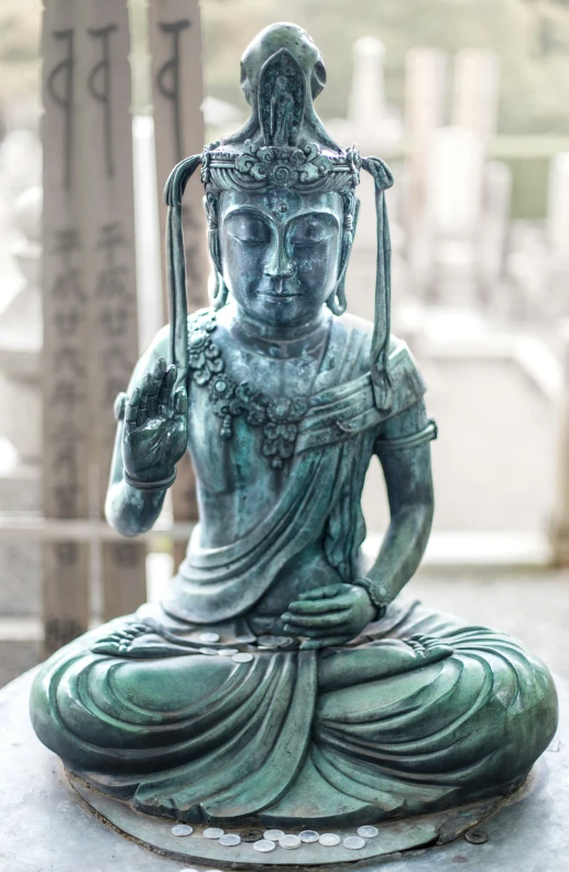 a statue of a meditating person with a halo