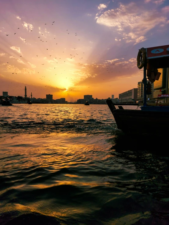 people in a small boat watching the sun rise