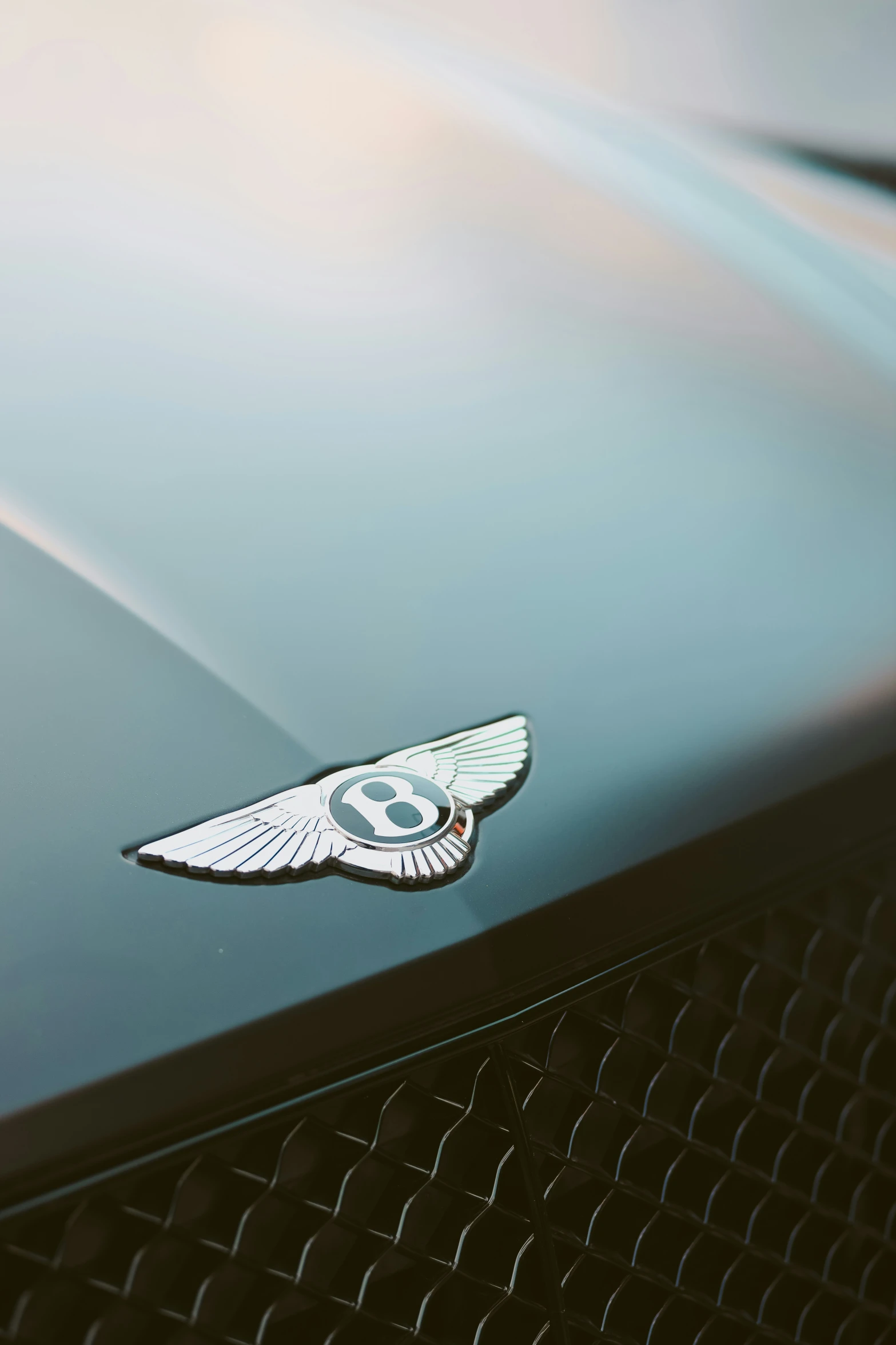 a bentley badge sits on the grille of a classic car