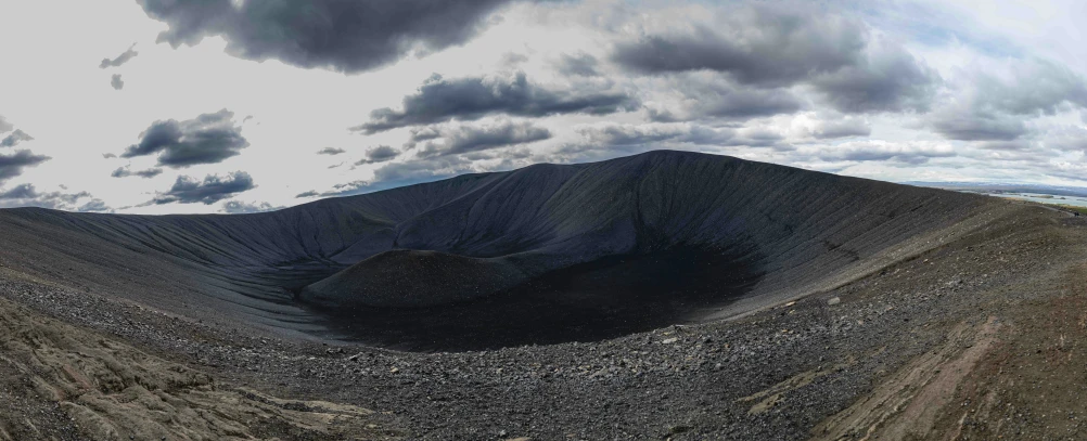 a mountain with sp slopes under cloudy skies