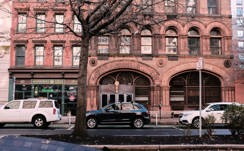 an old style building with a large tree in front