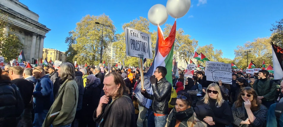 a crowd of people holding signs in the street