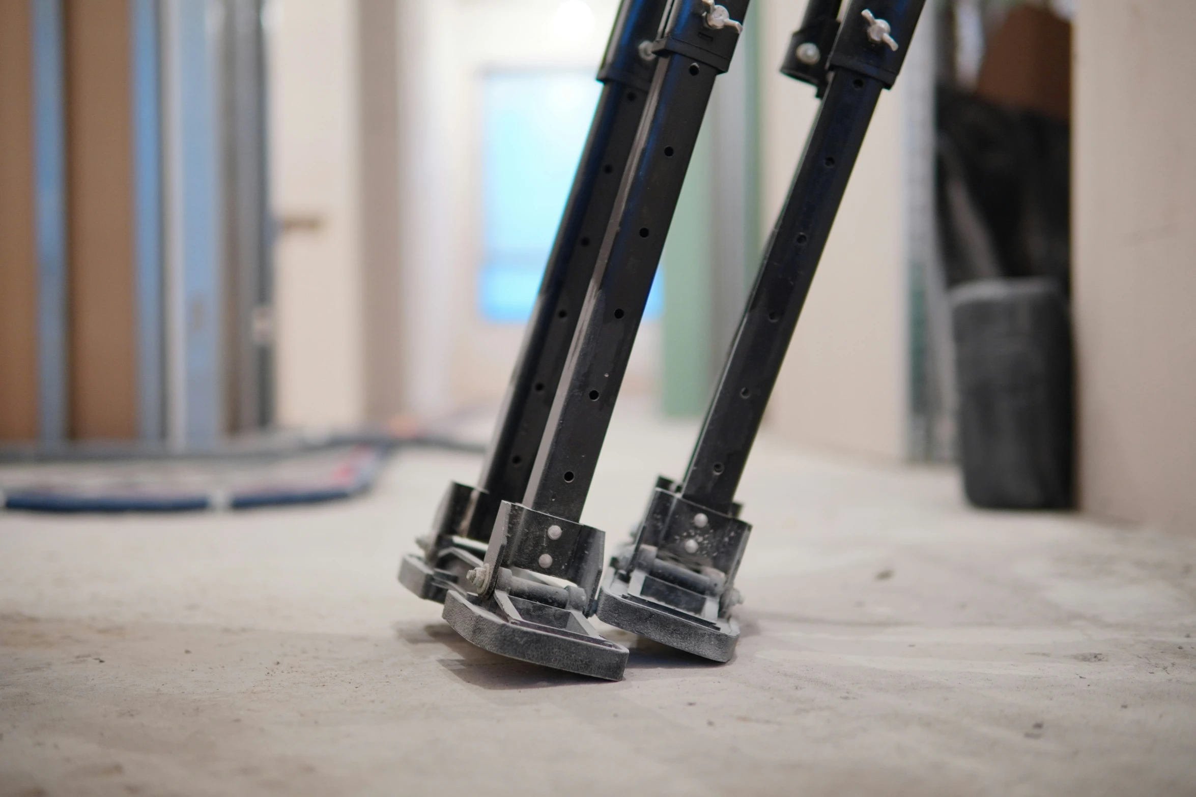 the legs and foot of a pair of skis on the floor