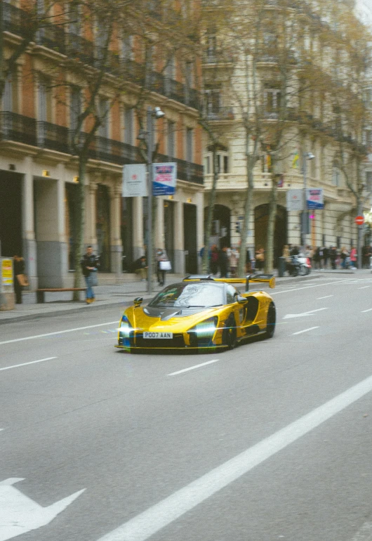 a very pretty yellow sports car in the street