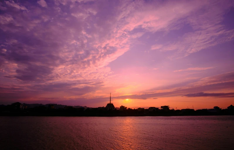 some purple and yellow clouds on the water