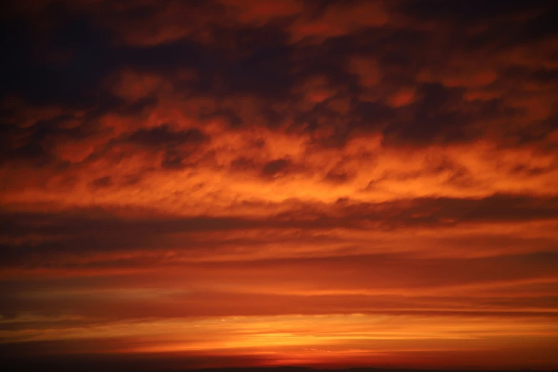 the sky is red, orange and black with the clouds