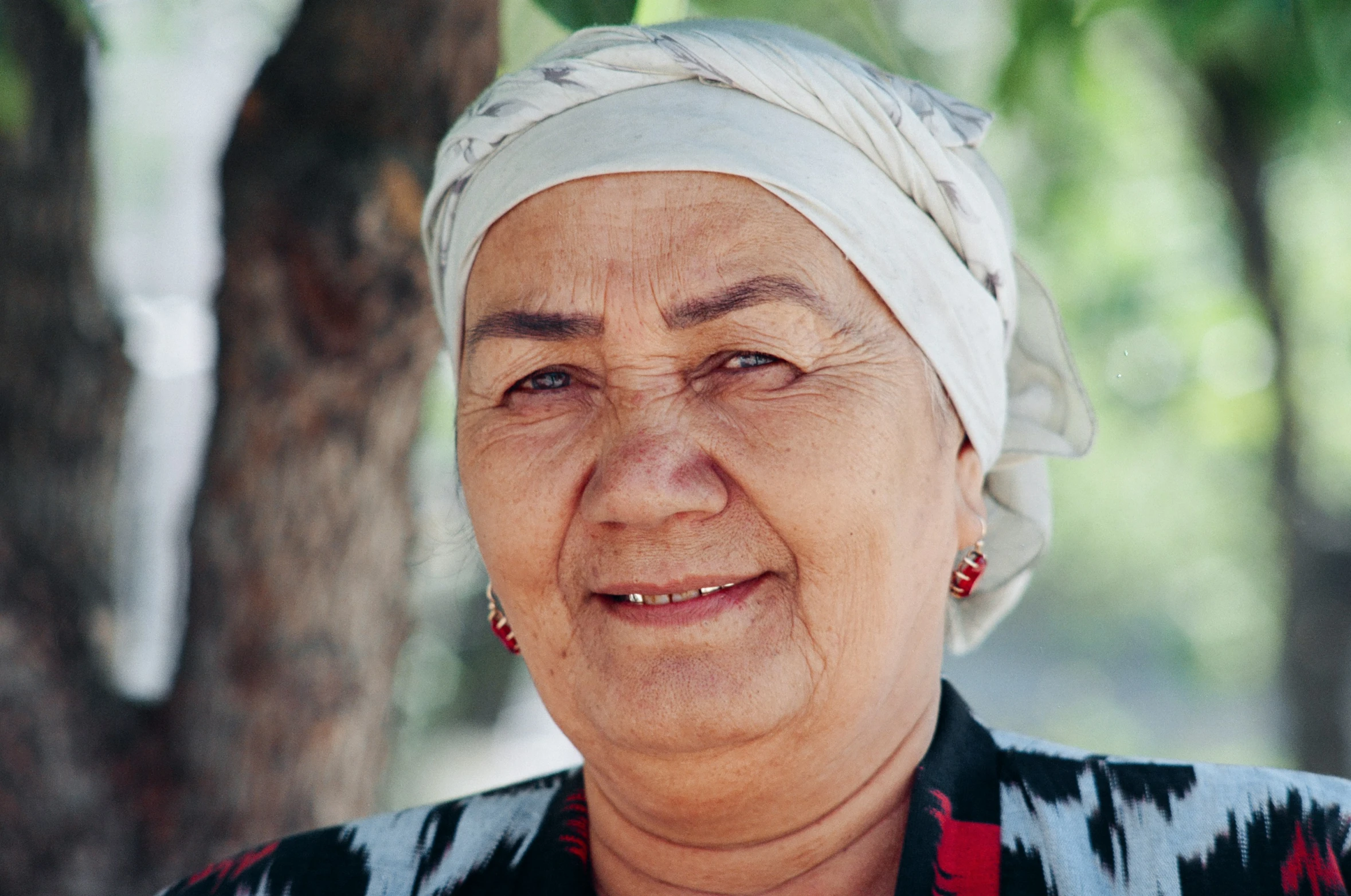 a woman in a white scarf smiling for a po