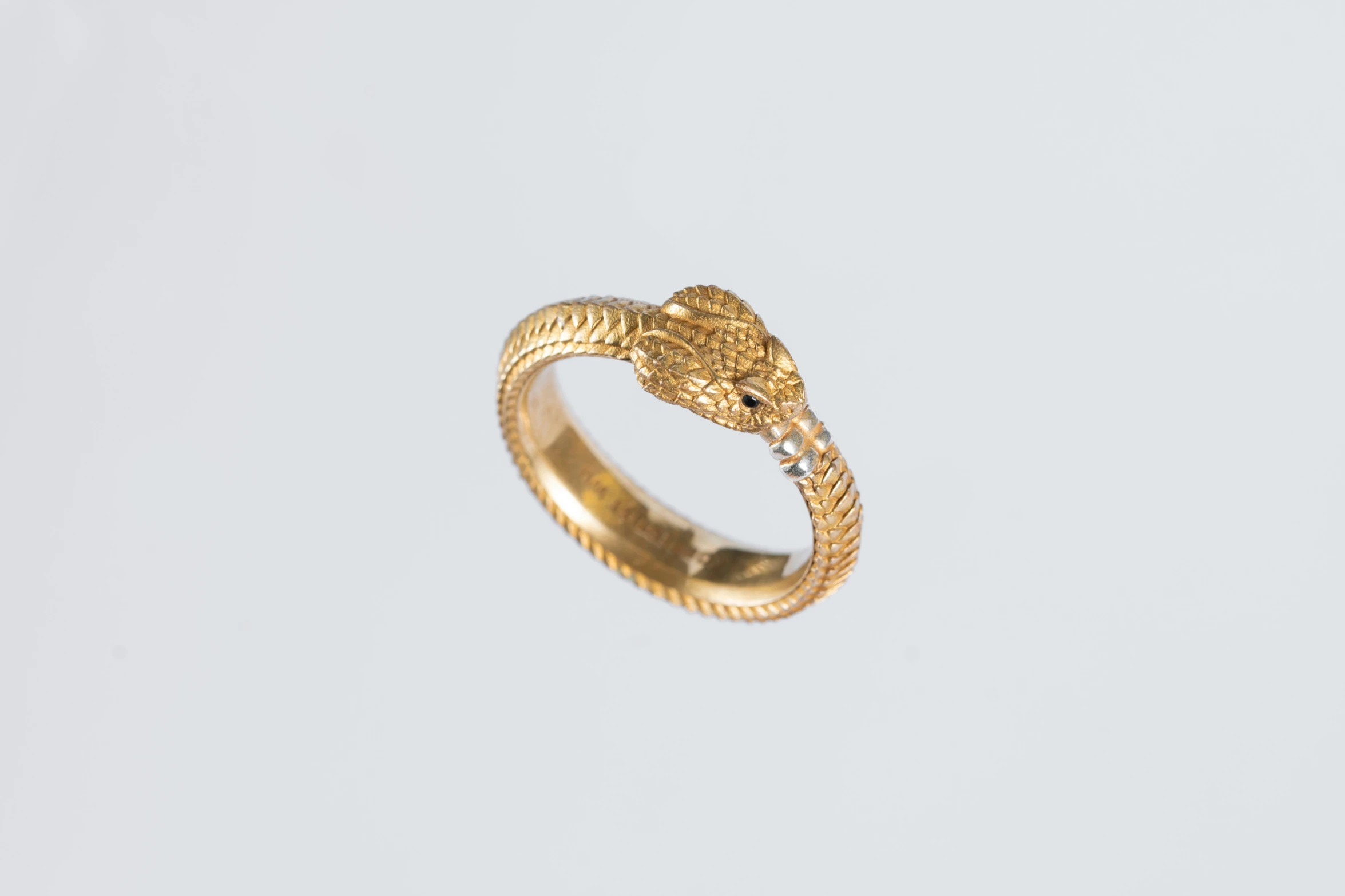 a yellow gold ring with a snake on it