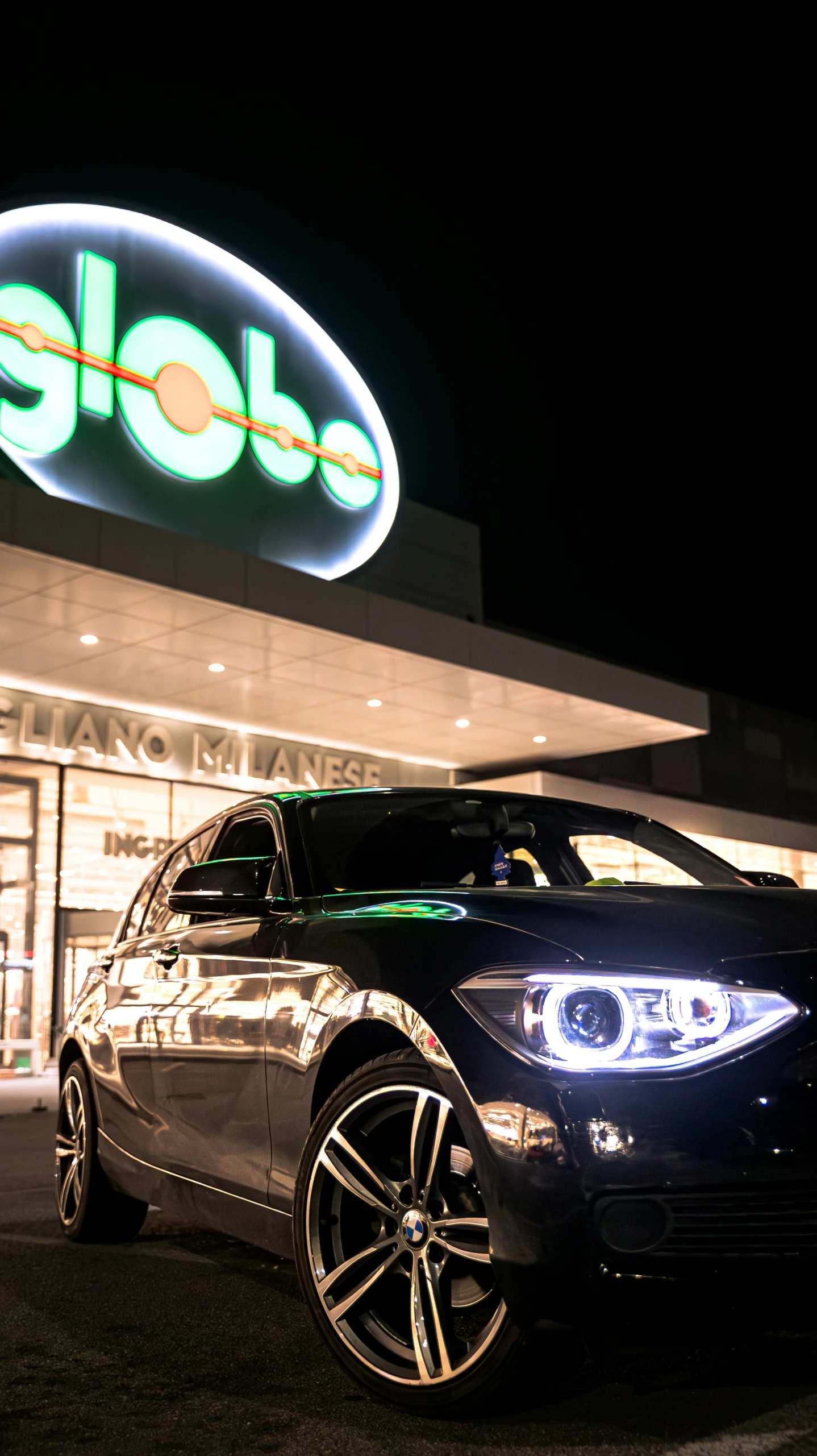 a car parked in front of a store at night