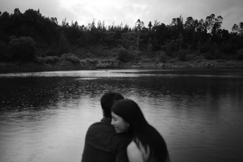 a couple emcing in front of a lake