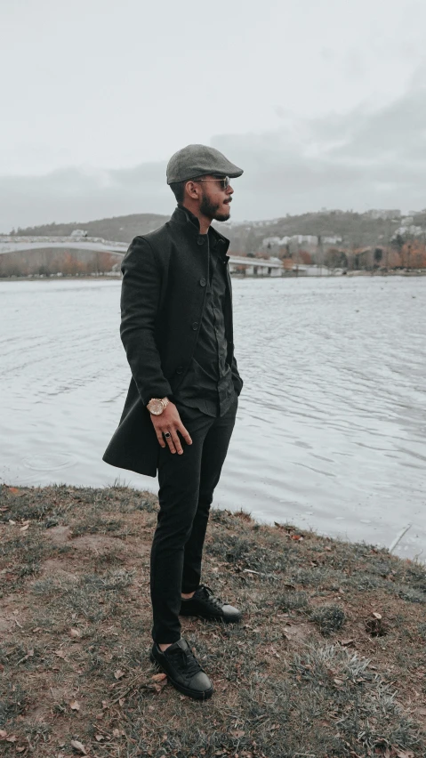 the man stands on the edge of a rocky beach