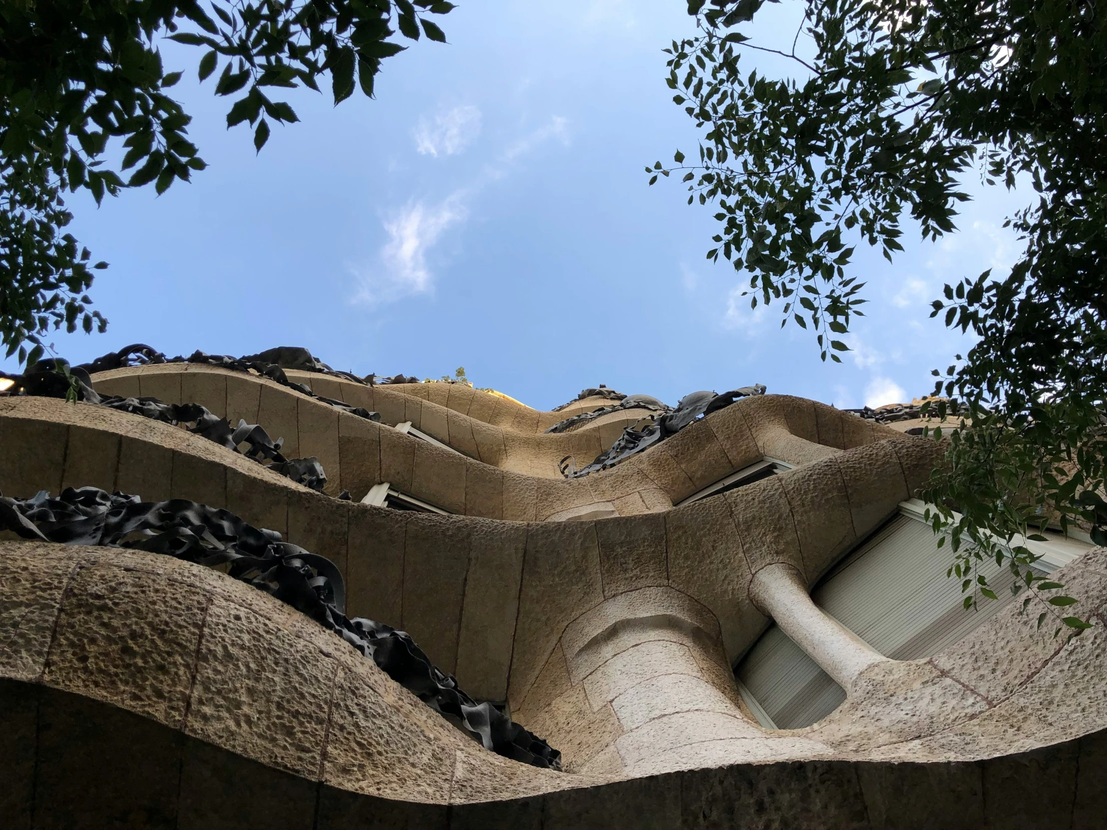 large concrete sculpture sitting next to a forest