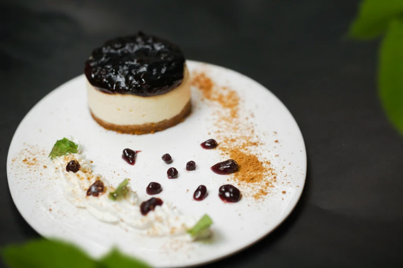 a white plate topped with a pastry and pieces of fruit