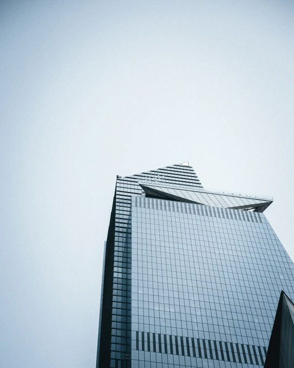 a building with the reflection of a plane in it's windows