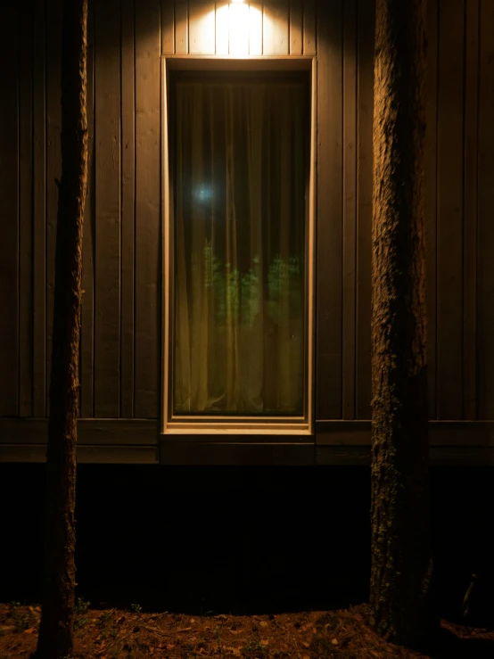 the front porch of a house at night with its light on