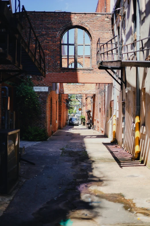 the view from an outside area, looking down a narrow alley with brick building