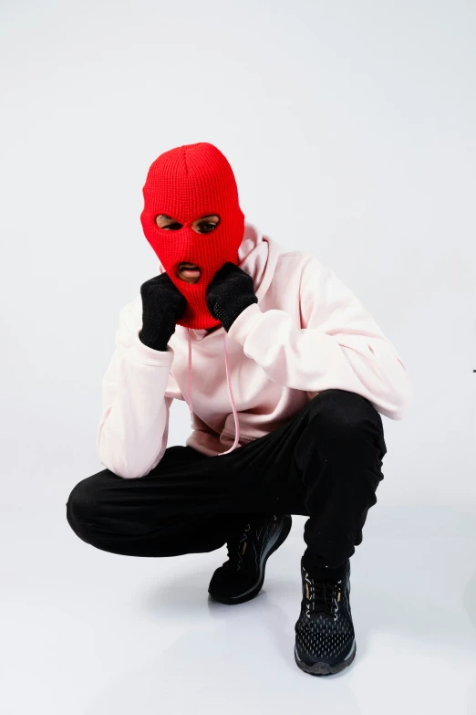 a man in a red mask sitting down