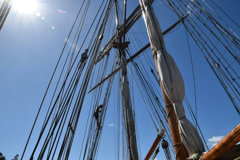 the mast of an old ship under a sun