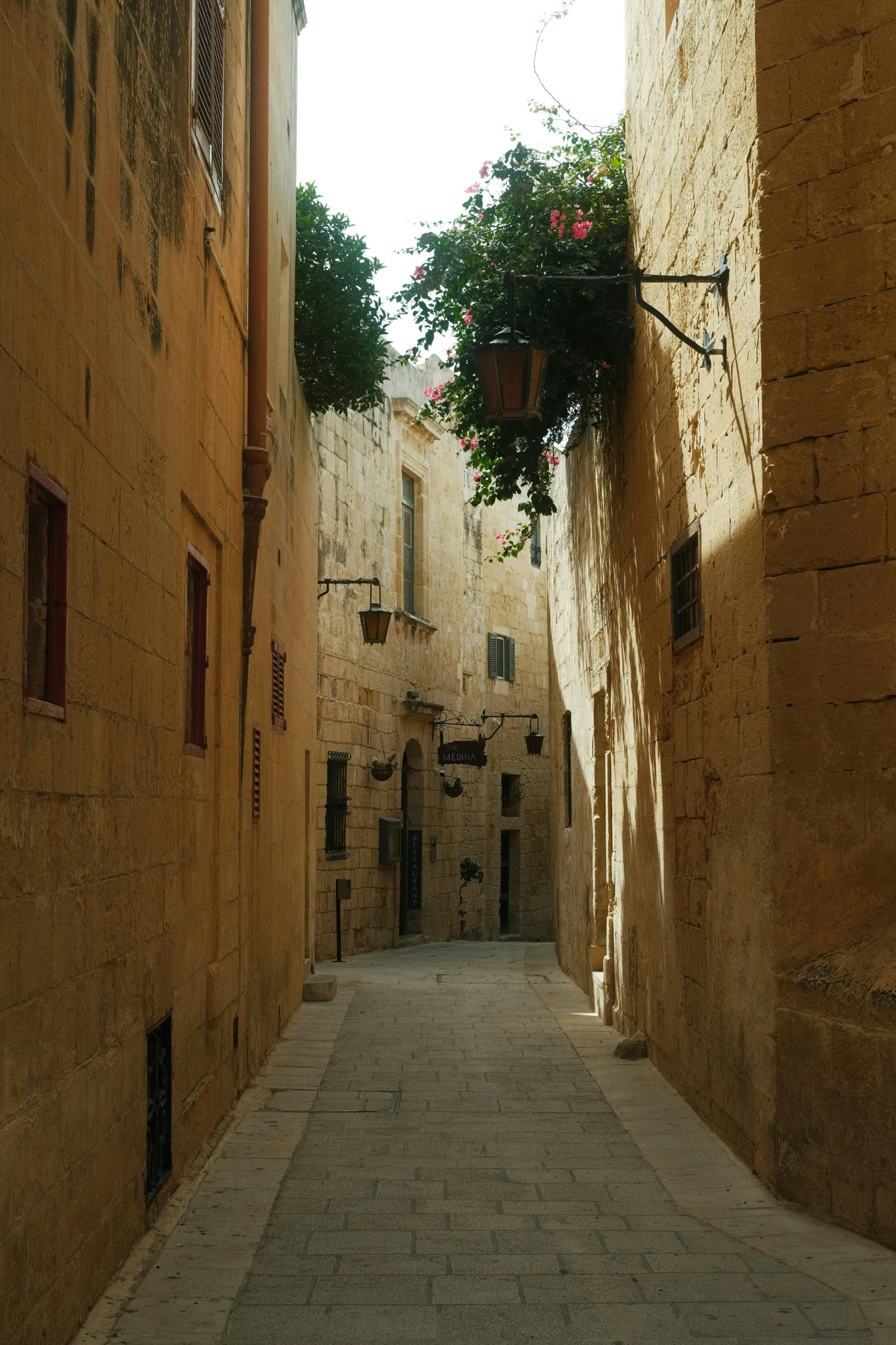 narrow street with flower box and stone wall