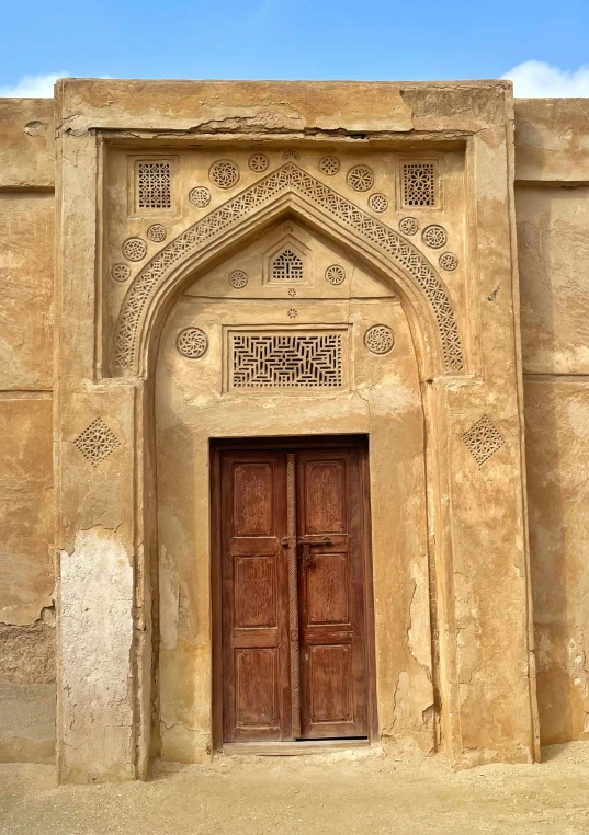 a big door in the side of an adobe building