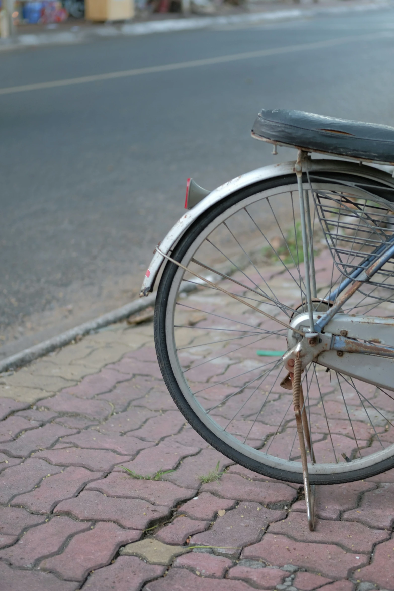 an old bicycle that is  to the side of a pole