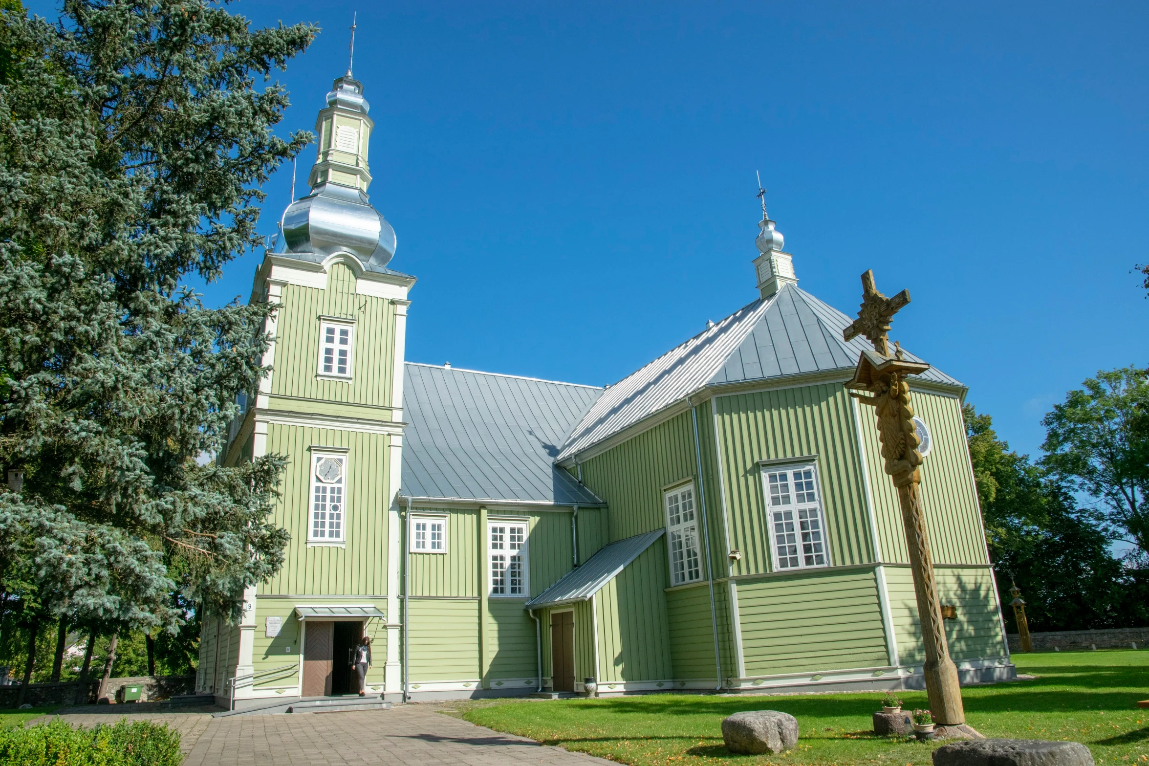 a tall green church with steeple on a sunny day