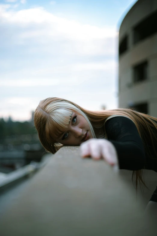 woman posing while leaning on the edge of a building