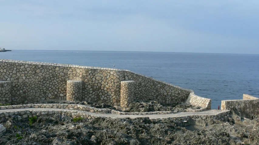 a cement wall on the edge of a cliff overlooking the ocean