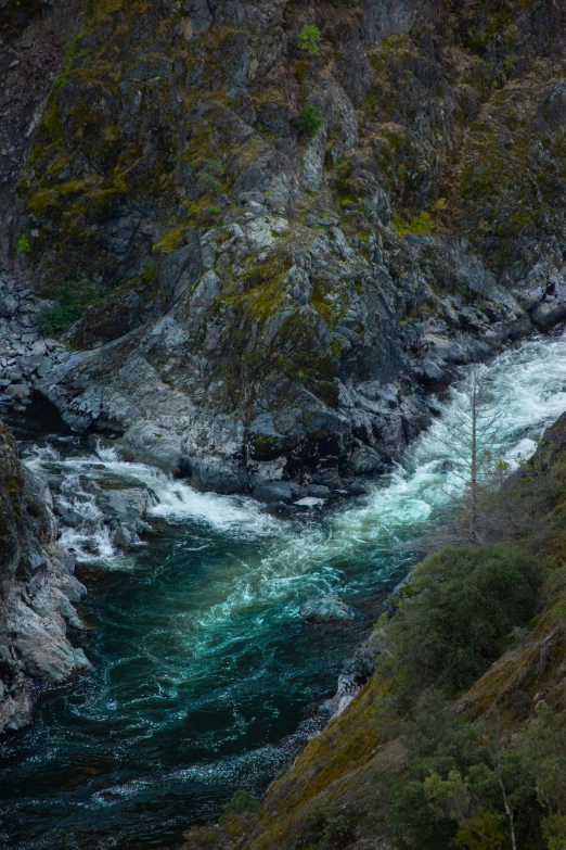 white water rushing under a high mountain