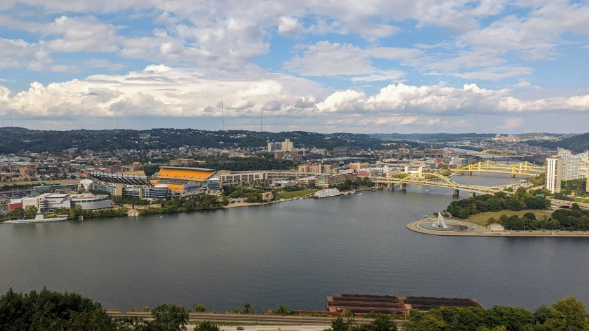 a lake is surrounded by green trees and buildings