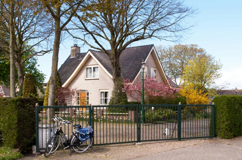 a bike propped up against a fence near a house