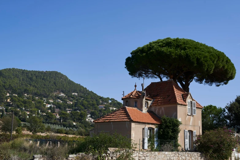 a mansion next to a lush green mountain side