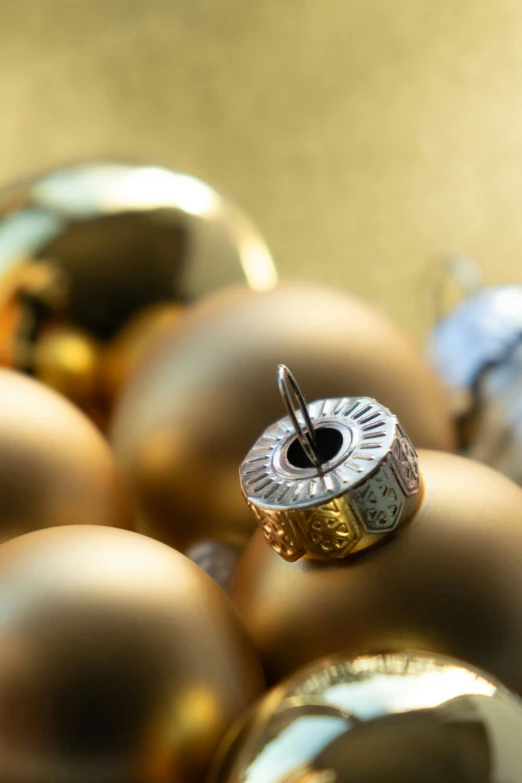 gold christmas ornaments and a brown bell with one silver bell