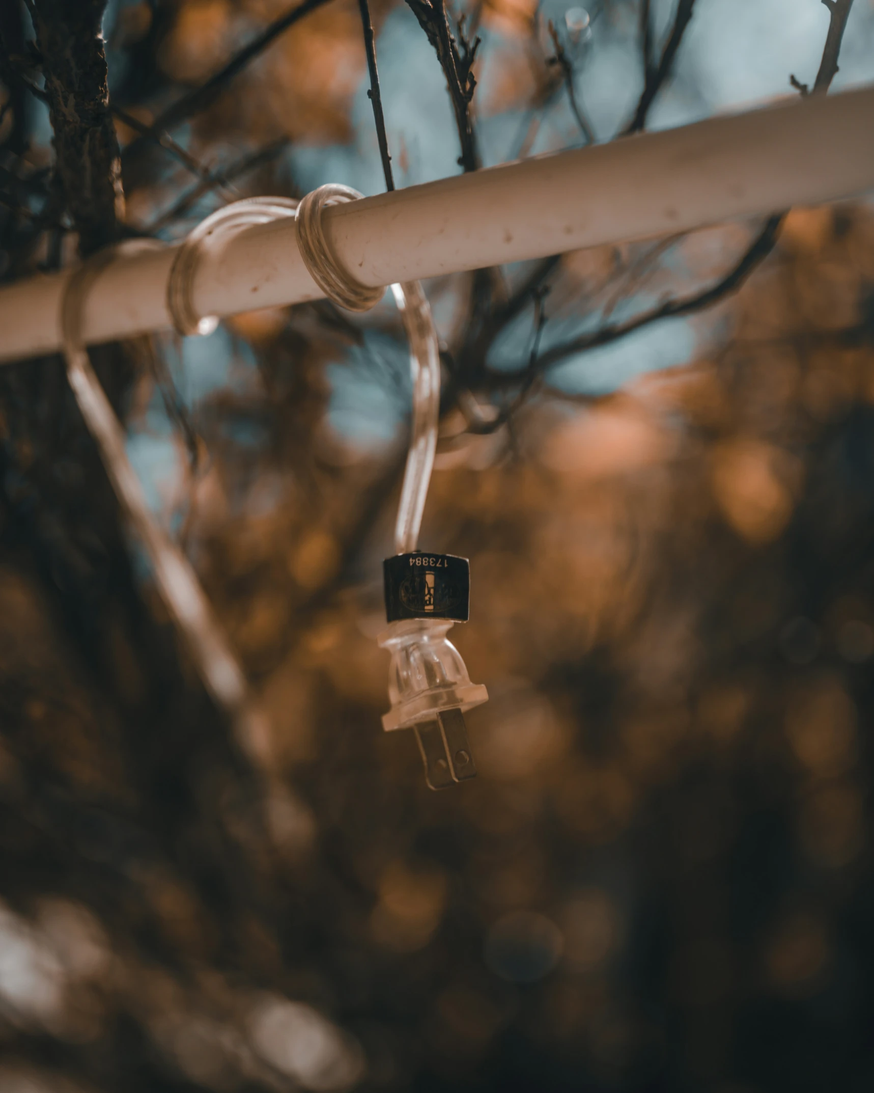 the small black and white padlock on a metal wire